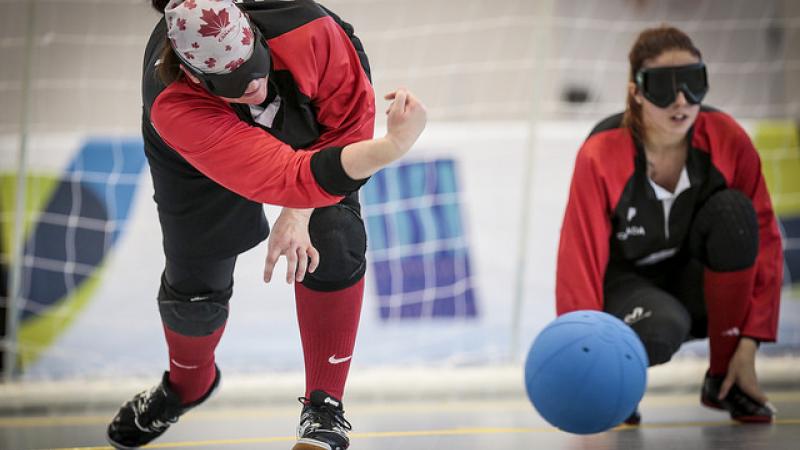 Woman goalball player rolls a ball