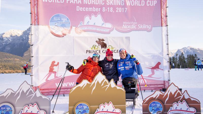 Podium shot of Andrea Eskau, Marta Zainullina and Birgit Skarstein embracing.