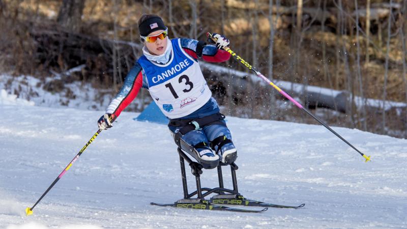 a female Para Nordic skier races towards the finish line