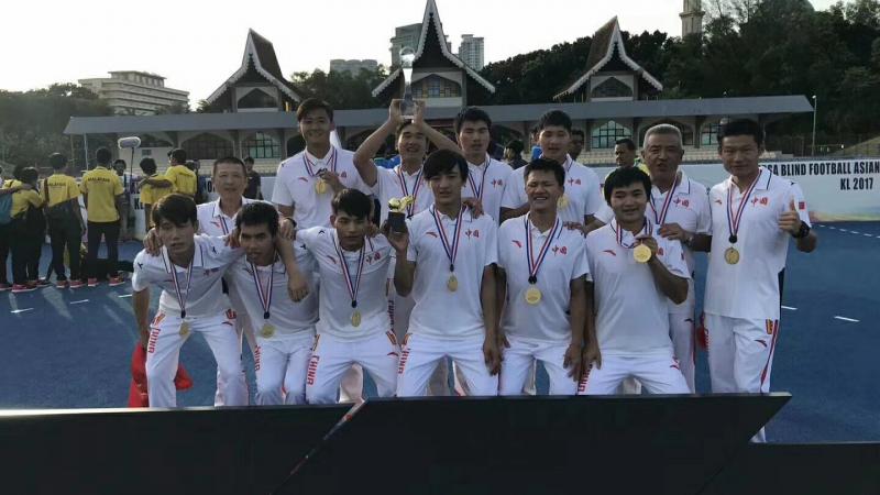 a group of blind footballers celebrate with their medals and trophies