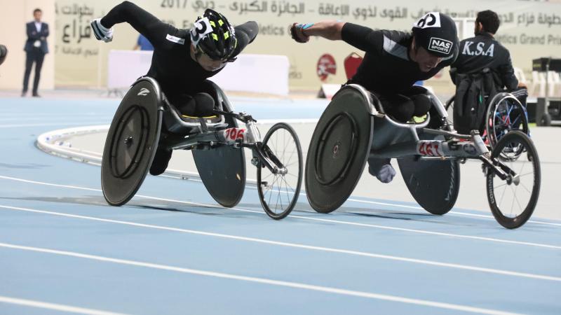 two male wheelchair racers come round the final bend