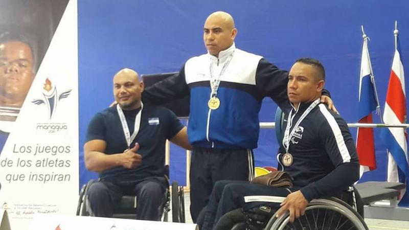 three male powerlifters ona podium