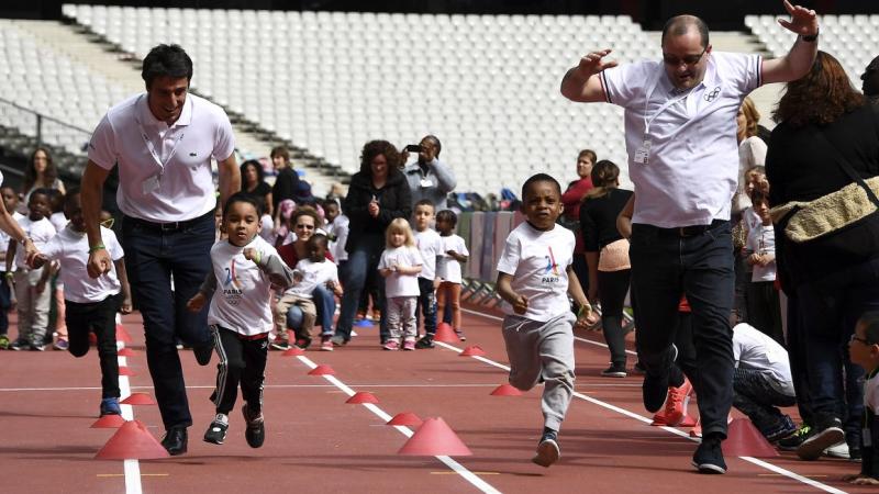 Men and children running on an athletics' track