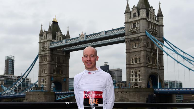 a man standing in front of London's Tower Bridge