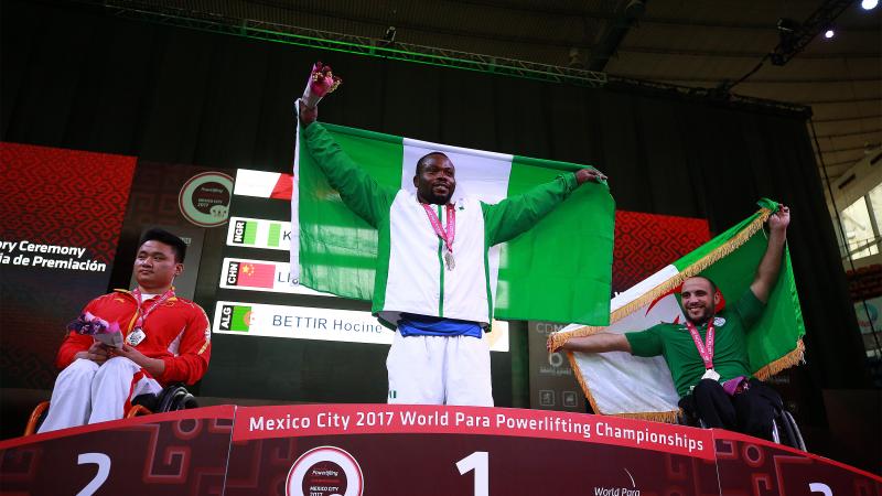 three male powerlifters on a podium