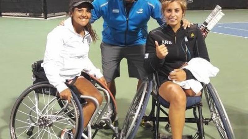 two female wheelchair tennis players with their coach