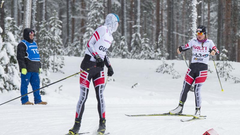 a female vision impaired skier and her guide