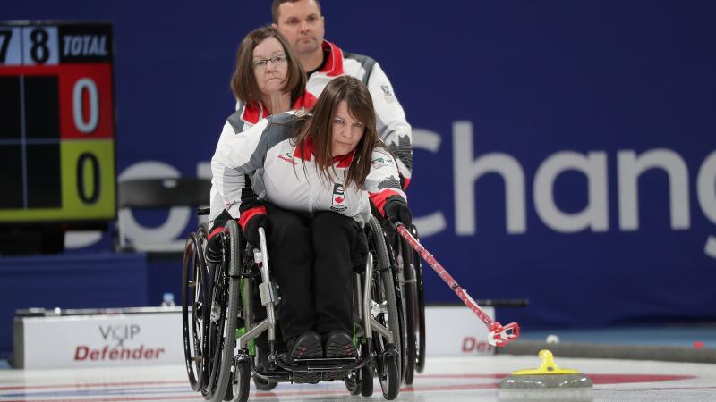 a female wheelchair curling releases a stone