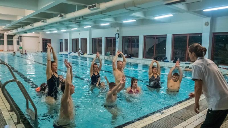 Expert trainers and athletes teaching children how to swim