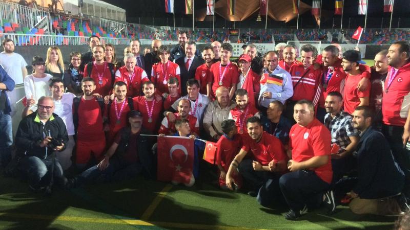 a group of blind footballers pose for a photo on the pitch