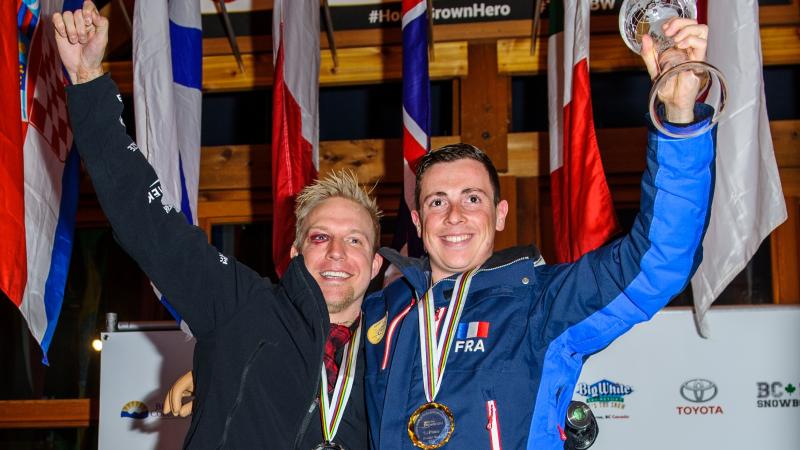 two male Para snowboarders on the podium with their medals