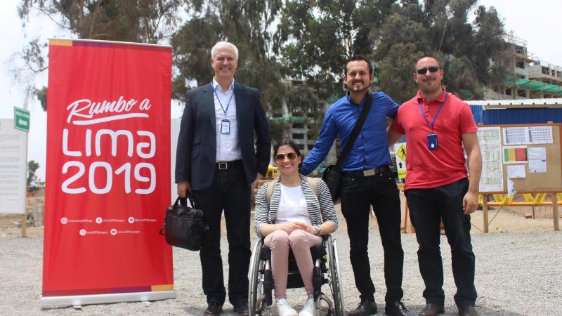 APC delegation visit Lima 2019 village four people smiling at a building site