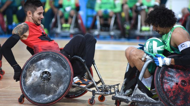 two male wheelchair rugby players clash for the ball