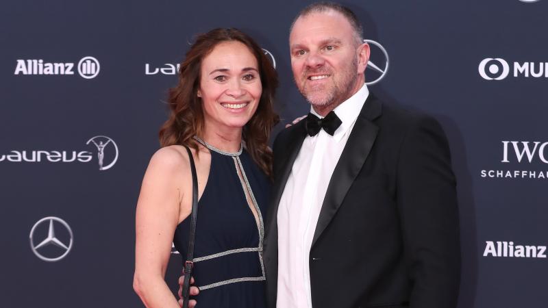 a woman and man stand on the red carpet