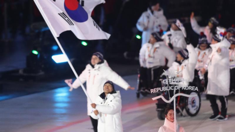 an athlete holds a South Korean flag