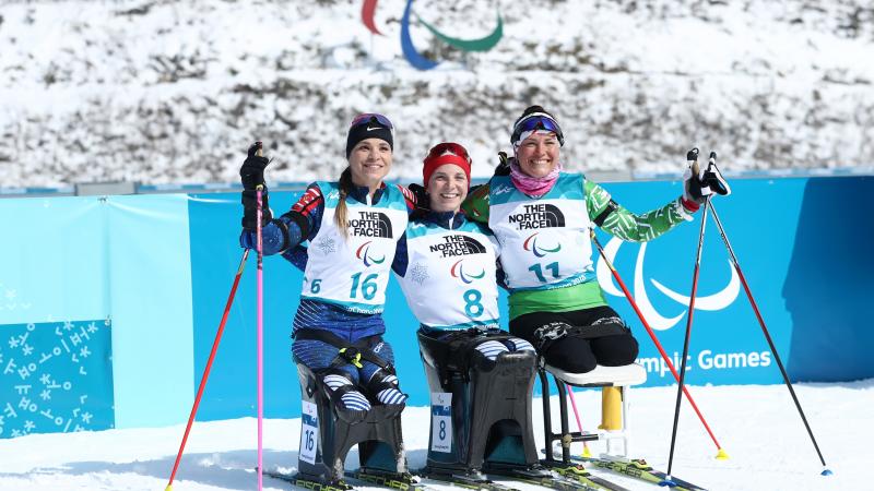 three female Nordic skiers hugging