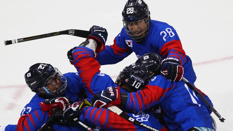 a Para ice hockey team hug in celebration