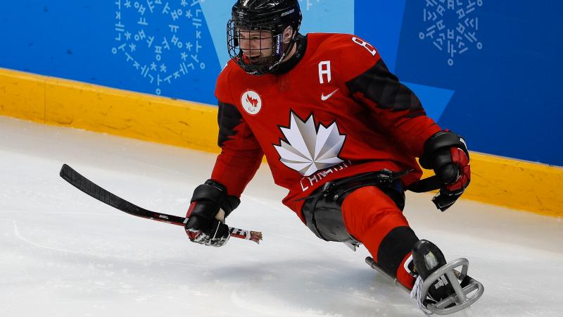 a male Para ice hockey player celebrates a goal