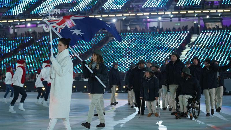 a female snowboarder carrying the flag of Australia