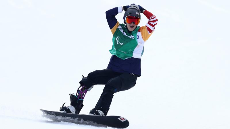 a female Para snowboarder celebrates on the snow