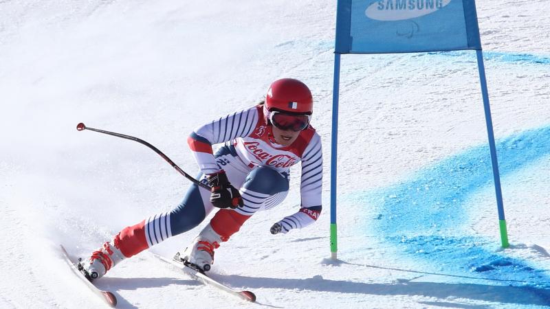 a female Para skier rounds a gate