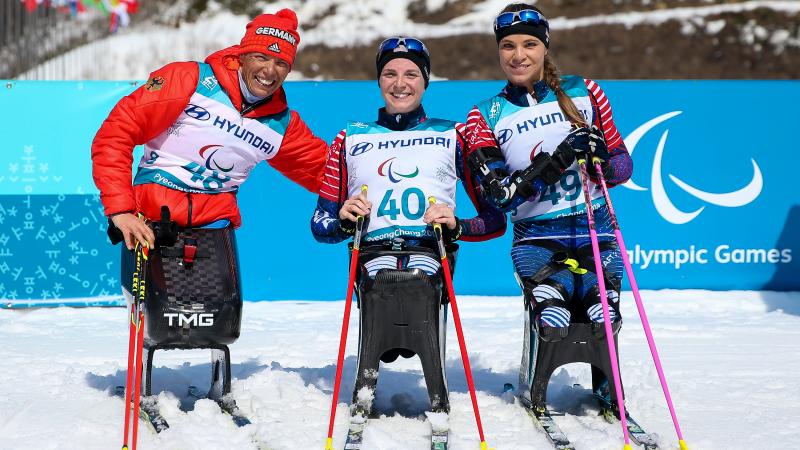 three female sit skiers celebrate their medals