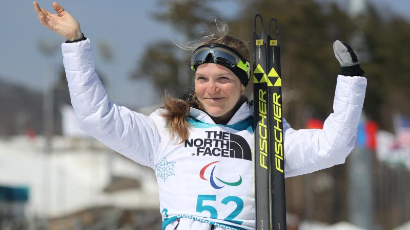 a female Para biathlete celebrates on the podium