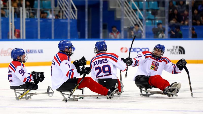 Para ice hockey players celebrating on the ice