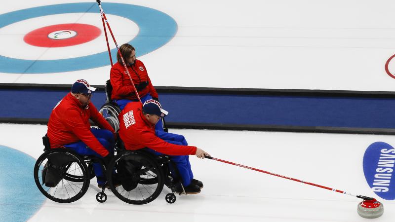 wheelchair curler throws a stone