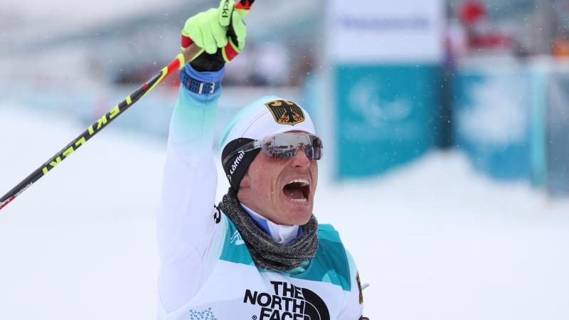 a male Para sit skier punches the air