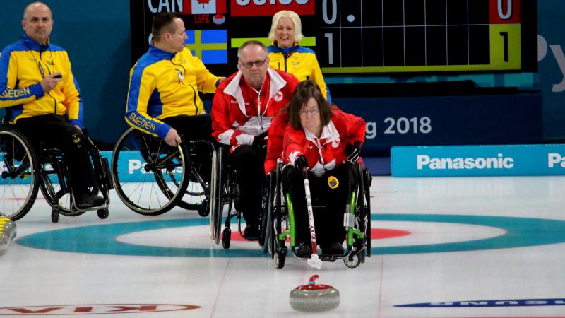 a female wheelchair curler plays a stone