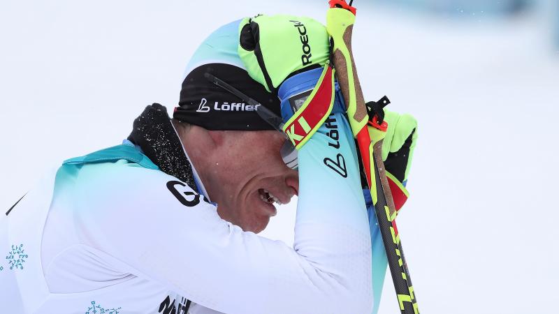 a male sit skier cries on the finish line