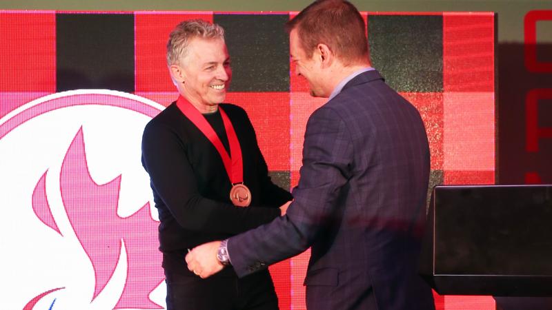 two men shaking hands and smiling