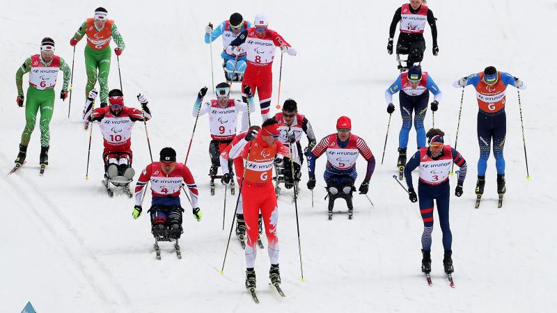 a group of cross-country skiers sprint for the finish line