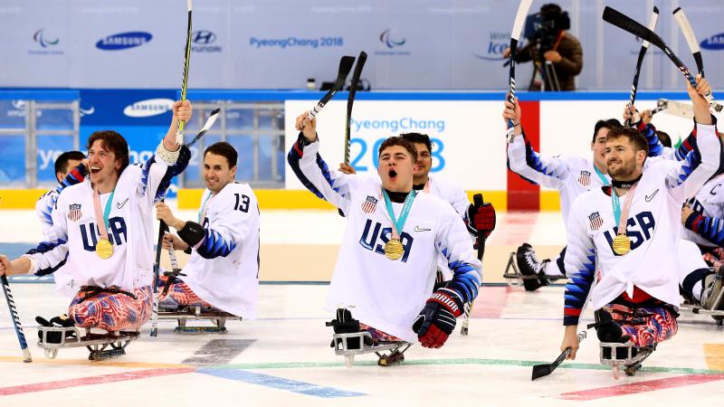 Para ice hockey players celebrating on the ice