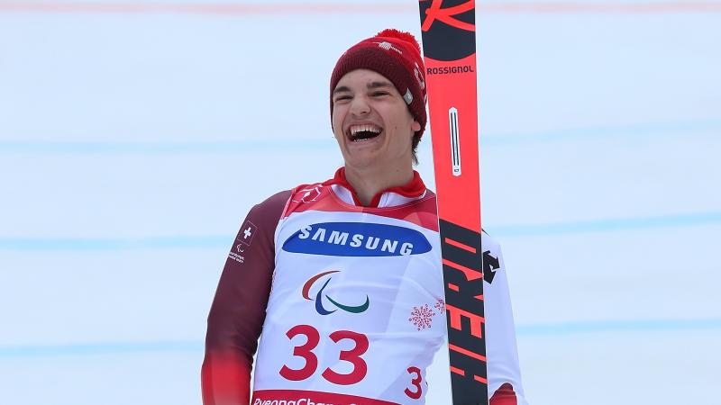 a male Para skier laughs in celebration