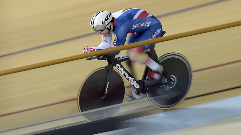 a male Para cyclist racing around a track