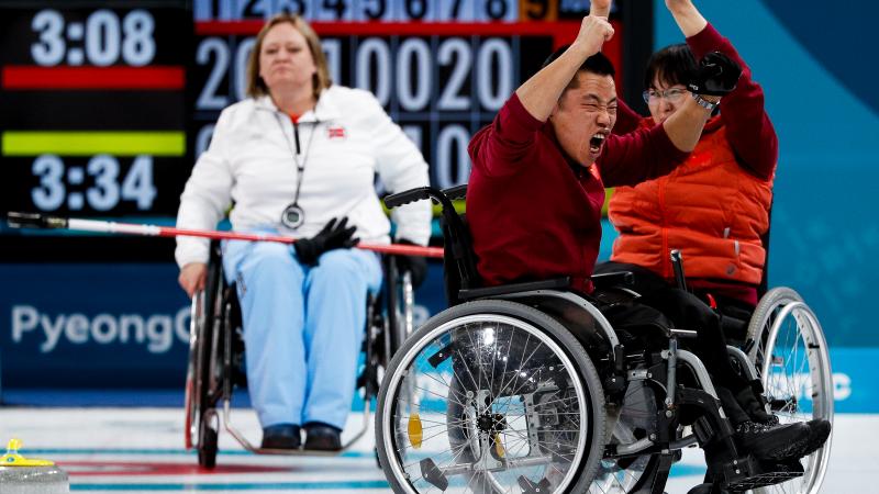 wheelchair curlers celebrating on the ice