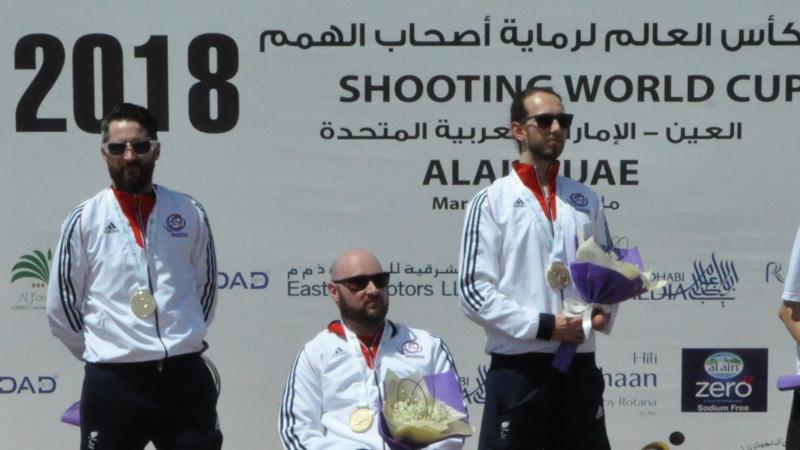 three male Para shooters on a podium