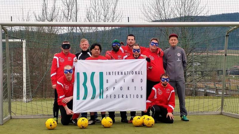 a group of blind footballers line up in goal
