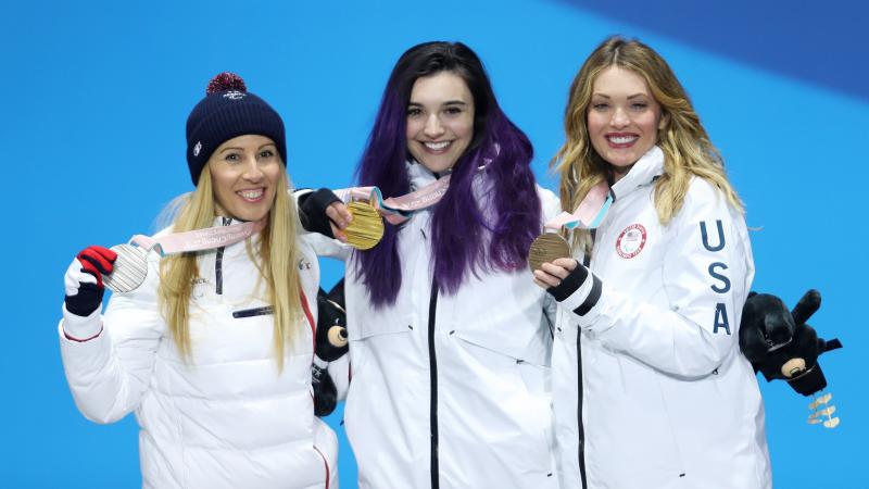 three female Para snowboarders on the podium