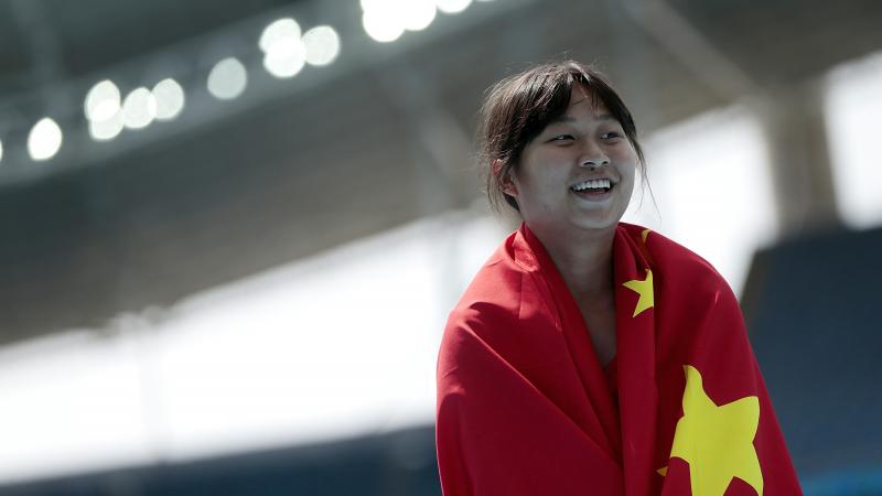 a female Para athlete wrapped in the Chinese flag