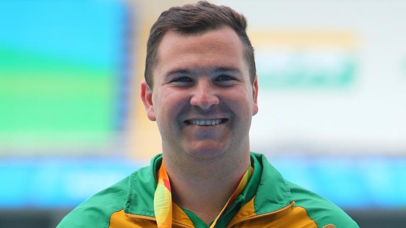 a male athlete smiling on the podium