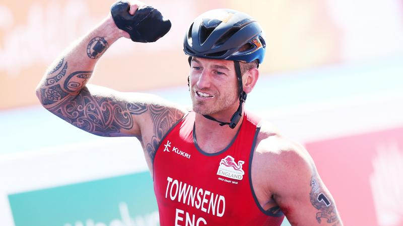 a male Para triathlete celebrates winning the race