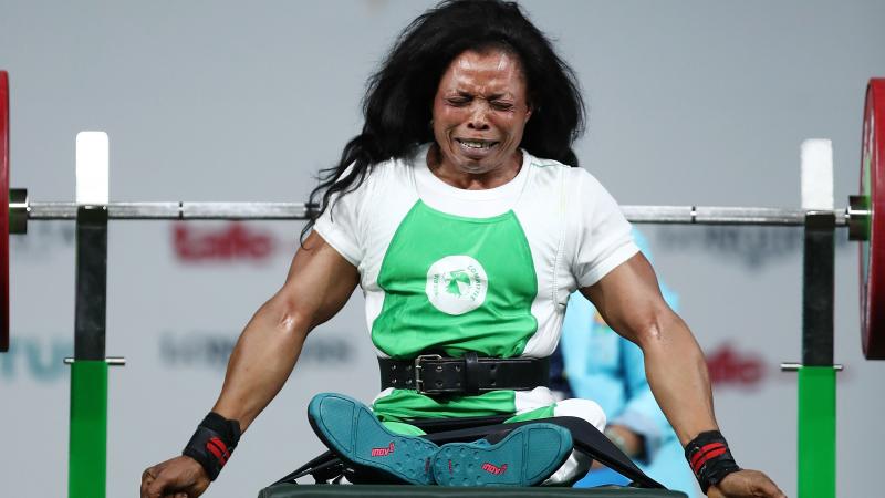 a female powerlifter celebrates on the bench