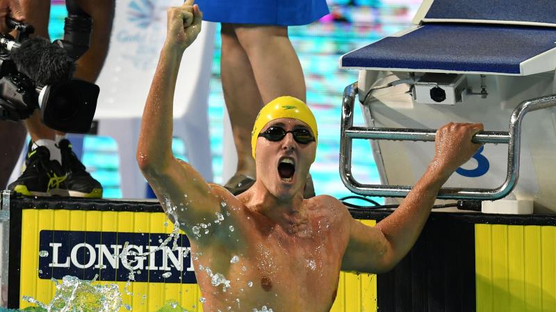 a male Para swimmer punches the air 