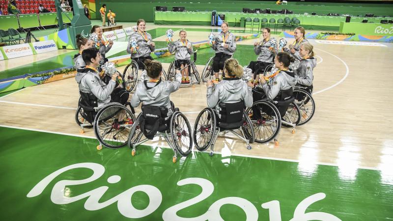 A group of female wheelchair basketballers in a circle