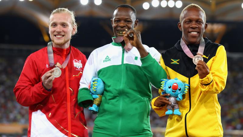 Suwaibidu Galadima celebrating on the podium together with James Arnott and Tevaughn Thomas at Gold Coast 2018.