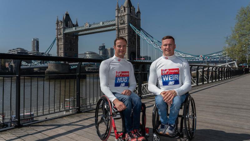 Two men in wheelchairs in London with the Tower Bridge in the background