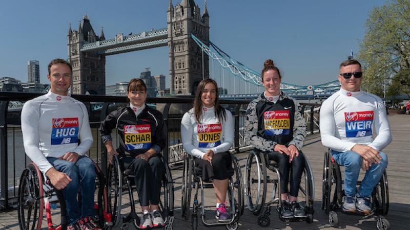 Five athletes in wheelchairs pose for pictures with London's Tower Bridge behind them